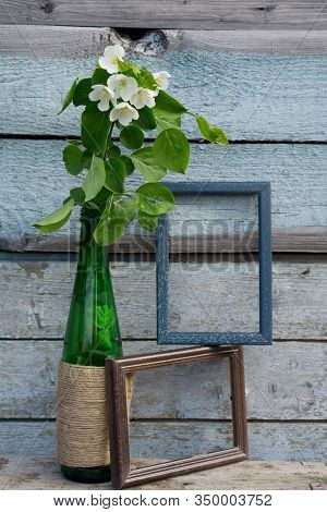 Creative Top View Apple Tree Blooming Flowers Brunch In Green Glass Bottle  On  Rustic Wooden   Back