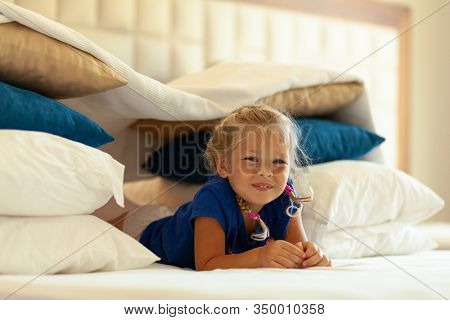 Little Cute Girl Built Impromptu Fort (castle, House) Out Of Pillows And Blankets On Bed. Children H