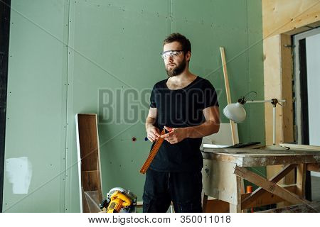 Tired Unhappy Man Standing With Corner Ruler In Rennovating Apartment.