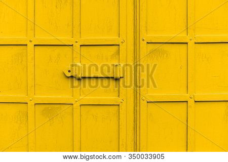 Old Metal Door With A Bolt Of Yellow Color. Iron Door Latch. Iron Bolt Of An Old Wrought Iron Door