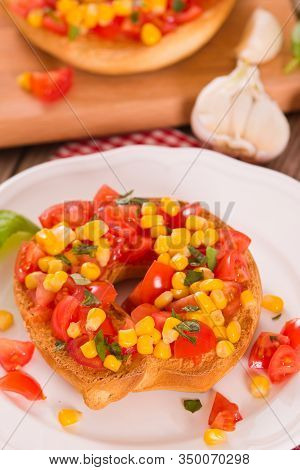 Friselle With Tomatoes And Mais On White Dish.