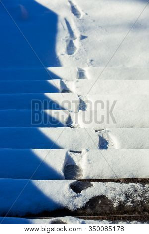 Footprints Of Boots On Snowy Steps. Stairs Covered With The Snow. Steps With Footprints In The Snow.