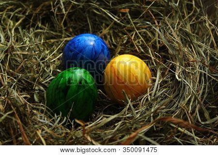 Three Colored Easter Eggs In Hay In The Eastertime