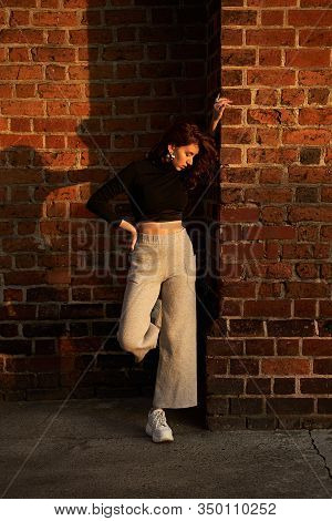 Portrait Of A Beautiful Sensual Redhead Girl Posing In Sunset Sunlight Wearing Light Grey Wide Leg H