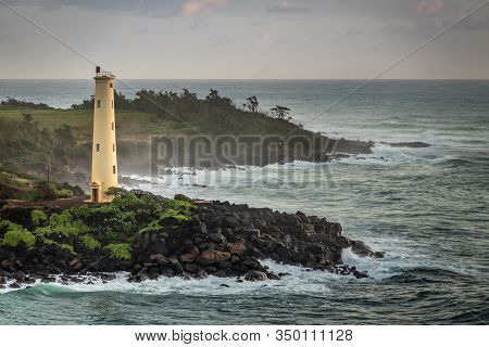 Nawiliwili, Kauai, Hawaii, Usa. - January 16, 2020: Yellow Ninini Lighthouse On Black Ocean-shore Ro