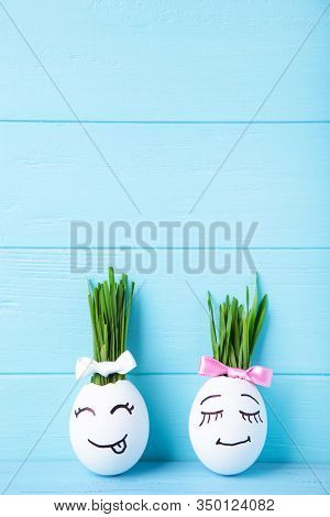 Funny Handmade Eggs With Hair Of Green Grass With Copy Space. Easter Concept On Blue Wooden Backgrun