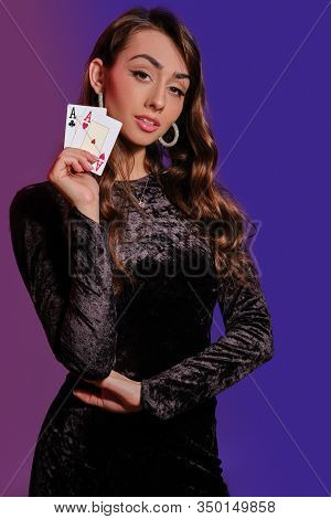 Brunette Woman In Black Velvet Dress Showing Two Playing Cards, Posing Against Coloful Background. G