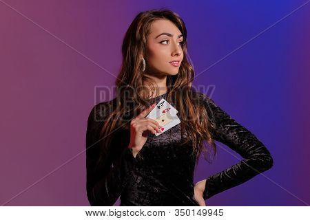 Brunette Woman In Black Velvet Dress Showing Two Playing Cards, Posing Against Coloful Background. G