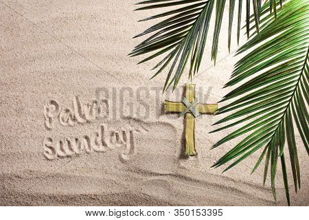 Cross And Palm Tree Leaves On Sand. Palm Sunday Concept. Top View