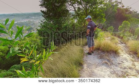Labuan,malaysia-feb 1,2020:a Hiking Man Is Standing On The Top Of Hill & Looking To The Landscape In