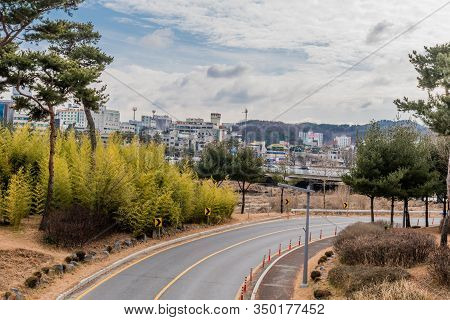 Daejeon, South Korea; January 28, 2020: Curved Road Through Urban Park With Buildings In Background 
