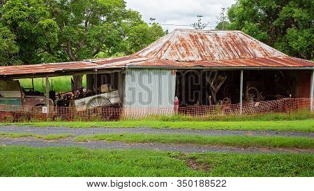 Old Dilapidated Shed Filled With Farm Vehicles And Implements Used By Early Settlers In The Past