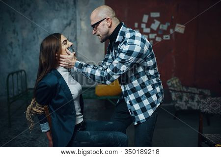 Maniac kidnapper taping his victim's mouth shut