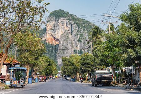 Prachuap Khiri Khan, Thailand - February 9, 2019: Country road with high cliff at background in Prachuap Khiri Khan district, Thailand.