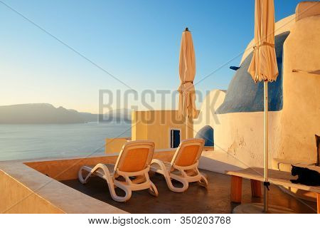 Leisure life settings with umberlla and chair in Santorini, Greece.