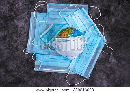 Earth Planet In Protective Medical Mask Isolated On Dark Background. Novel Rapidly Spreading Coronav