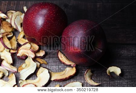 Dried Apple Chips And Two Red Apples On A Brown Wooden Table. Organic Natural Food. Close Up. Top Vi