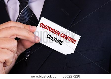 Businessman Putting A Card With Text Customer-centric Culture In The Pocket