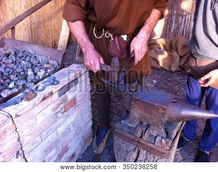 A Blacksmith Artisan At Work During A Representation Of Medieval Life In An Italian Fair