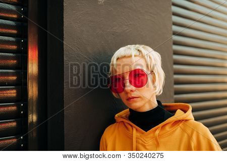blond lesbian woman with red singlasses 