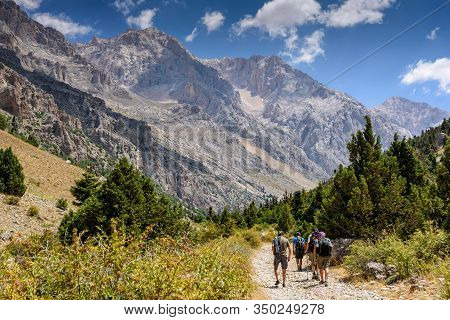 Turkey, Chamard - August 3, 2019: Tourists Walk Along The Road Through The Mountain Landscape In The