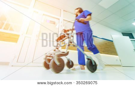 Patient On Rollator With Hand Brakes Moving In Hospital