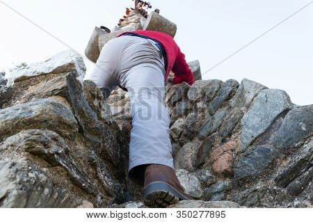 Man Climbing With His Foot In The Foreground On Rock