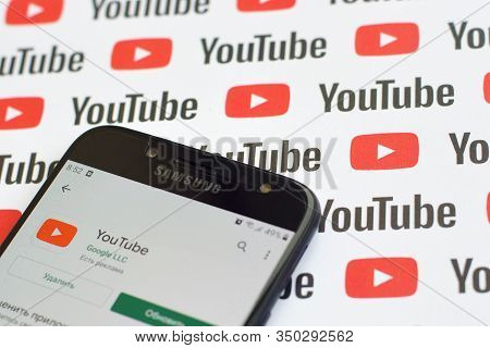 Youtube App On Samsung Smartphone Screen On Paper Banner With Small Youtube Logos And Inscriptions. 