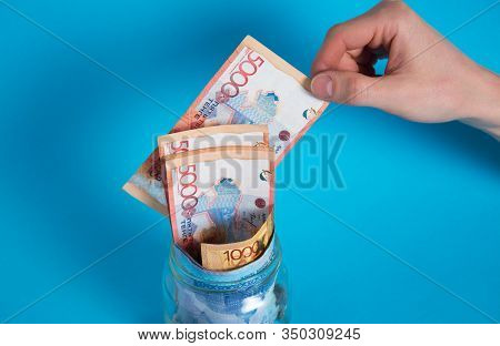 Get Tenge Out Of A Glass Jar. Put Money In A Glass Jar. Kazakhstan, Kz, Kzt. Banknote, Paper Currenc