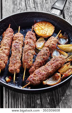 Spicy Kefta Kebab Of Ground Beef And Lamb Meat Grilled On Skewers Served On A Skillet With Roasted G
