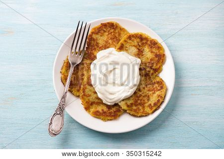 Traditional Latkes Fritters With Sour Cream On Light Blue Textured Background, Top View
