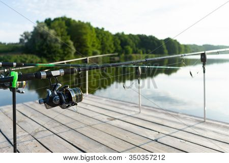 Carp Fishing On Beautiful Blue Lake With Carp Rods And Rod Pods In The Summer Morning. Fishing From 