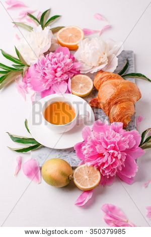 Breakfast For Valentines Day With Cup Of Tea, Peony Flowers And Croissant On Gray Murble Table And W