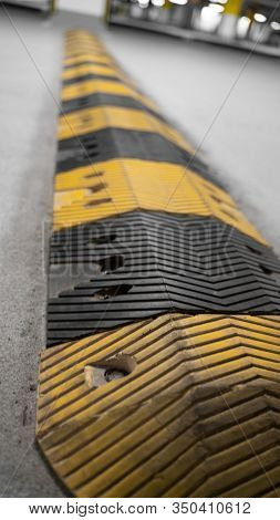Traffic Safety Speed Bump On An Asphalt Road In A Parking Area. Speed Bumps (or Speed Breakers) Are