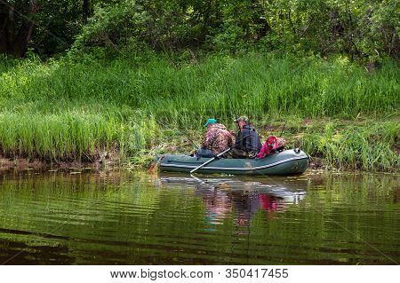 Tuzha, Russia - June 15, 2019: Fishermen Catch Fish On A Rubber Boat On A Forest River. Pizhma River
