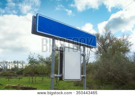 Blue Empty Road Name Sign, Isolated, Large Detailed Roadside Signage, In A Blue Sky