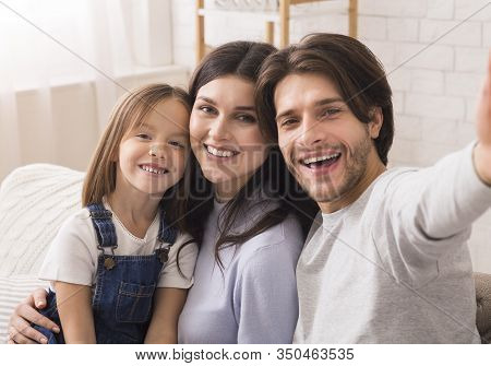 Capturing Happy Moments. Self-portrait Of Millennial Parents With Cute Little Daughter Posing For Se