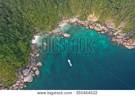 Aerial photo of scuba dive liveaboard boat beside tropical island