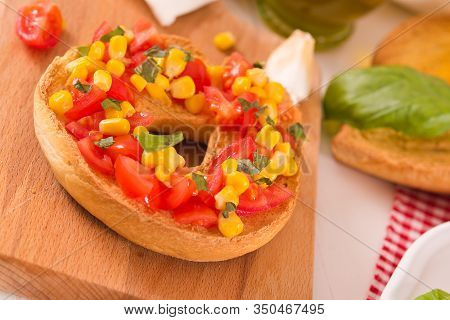 Friselle With Tomatoes And Mais On White Dish.