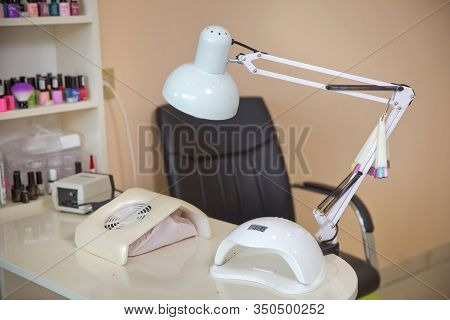 White Lamp On White Table With Nail Tool . Work Place Of Nail Amster With Manicure Tools, Uv-led Lam