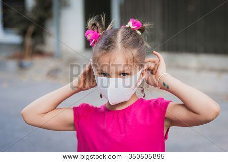 Girl wearing facial disposable mask to avoid viral infection. Virus protection