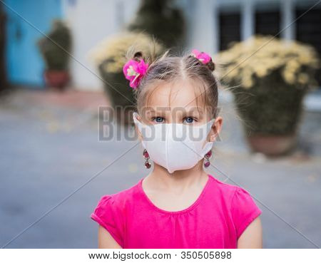 Girl wearing facial disposable mask to avoid viral infection. Virus protection