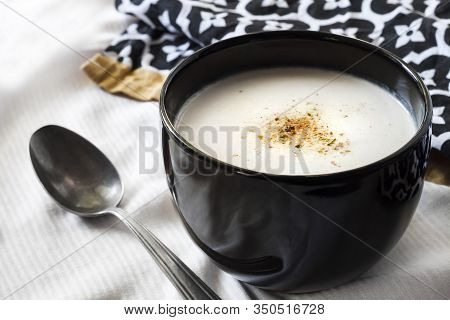 Cauliflower Soup (creme Du Barry) In Black Bowl On White Background With Black And White Cloth. Fren