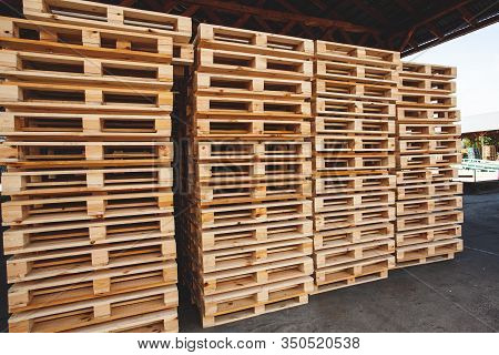 The Multiple Stacks Of Wooden Pallets In The Stock
