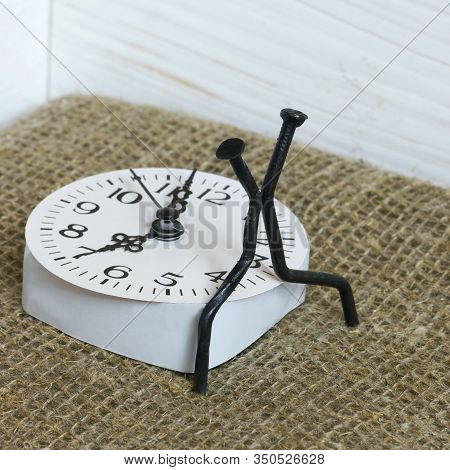 Figurines Of Man Made From Carpentry Nails. Sit On The Watch Dial Back To Back. Symbol Of The Inexor