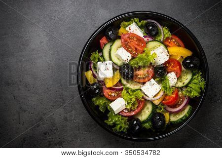 Greek Salad. Vegetable Salad From Tomato, Cucumber, Feta Cheese And Olive Oil On Black Stone Table. 