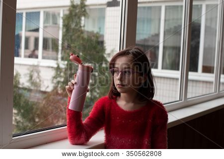 Girl With Cup. Schoolgirl Girl In Glasses Drinks Water From A Thermomug.a Schoolgirl Drinks Tea, Jui
