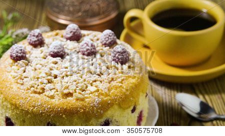 Yellow Cake With Powdered Sugar And Raspberries, The Girl Decorates With Mint. A Close-up.