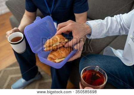 Two People Hsharing Sandwiches For Breakfast And Having Tea