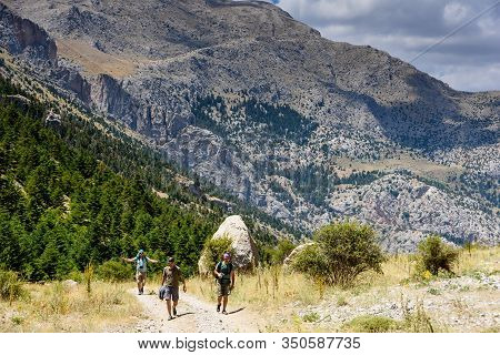 Turkey, Chamard - August 3, 2019: Tourists Walk Along The Road Through The Mountain Landscape In The
